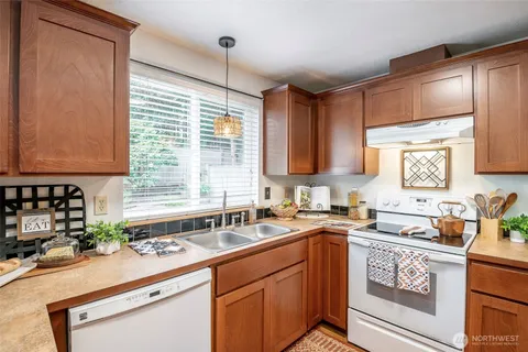 a kitchen with a sink stove top oven and cabinets