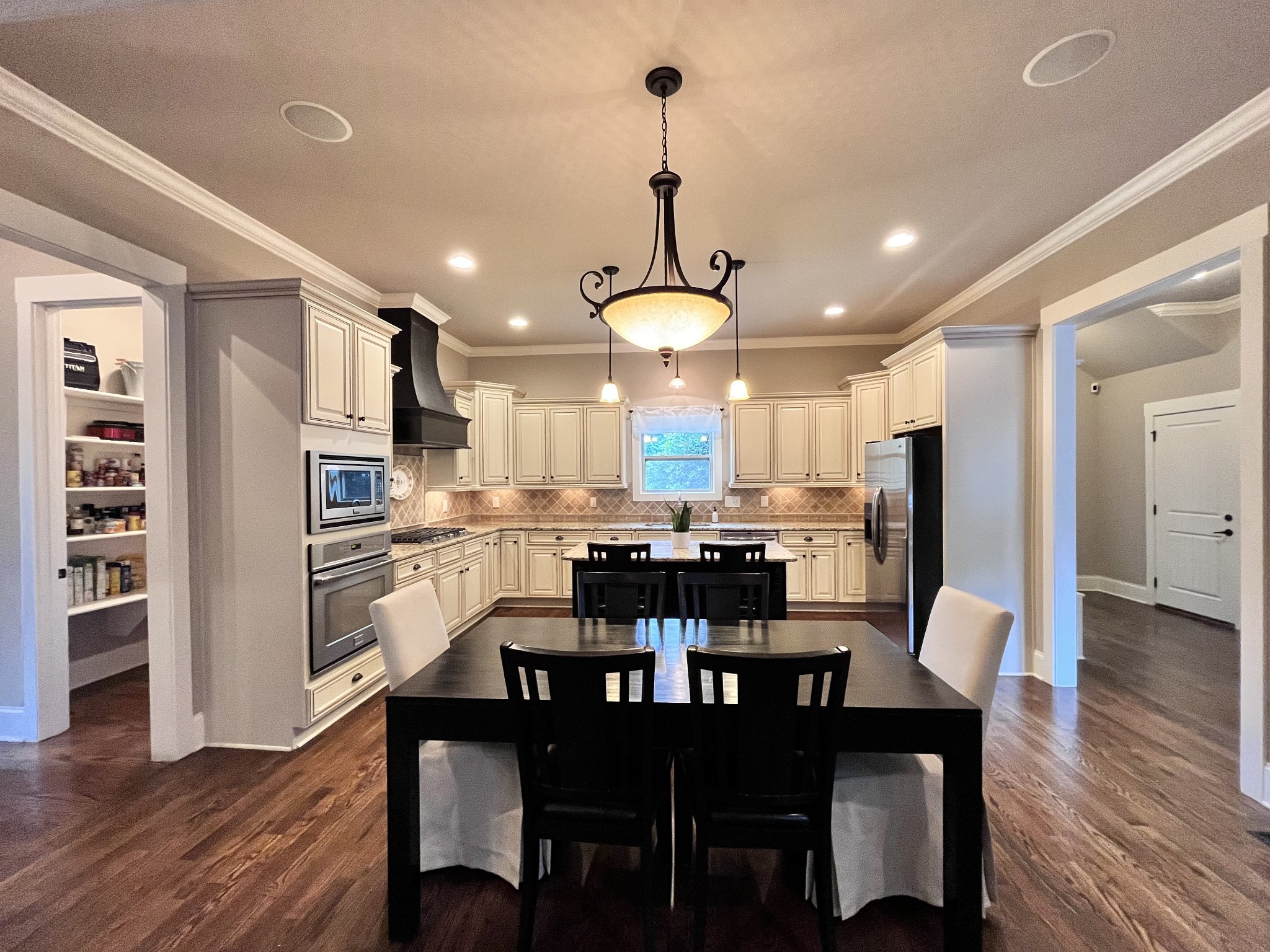 2667 Sporting Hill Bridge Road Thompson's Station, TN 37179 - Photo 7 of 42 a dining room with stainless steel appliances kitchen island granite countertop a dining table chairs and a refrigerator