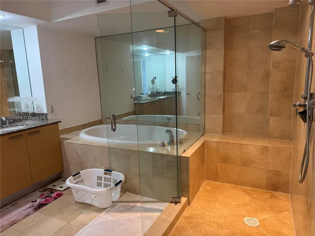 a bathroom with a sink a toilet a mirror and shower