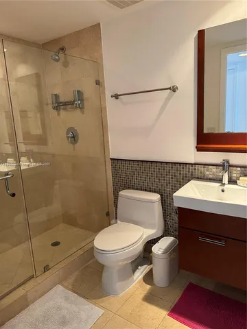 a bathroom with a granite countertop toilet a sink and shower