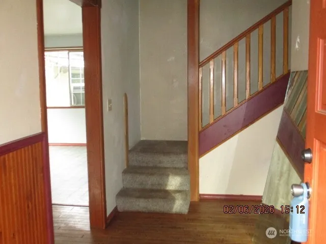 a view of staircase with lots of frames on wall and wooden floor