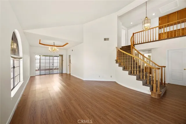 an empty room with wooden floor door and windows