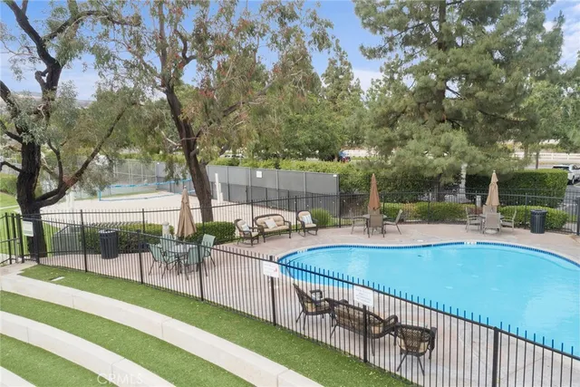 a view of a swimming pool with outdoor seating and city view