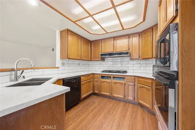 a kitchen with stainless steel appliances granite countertop a sink a stove and cabinets