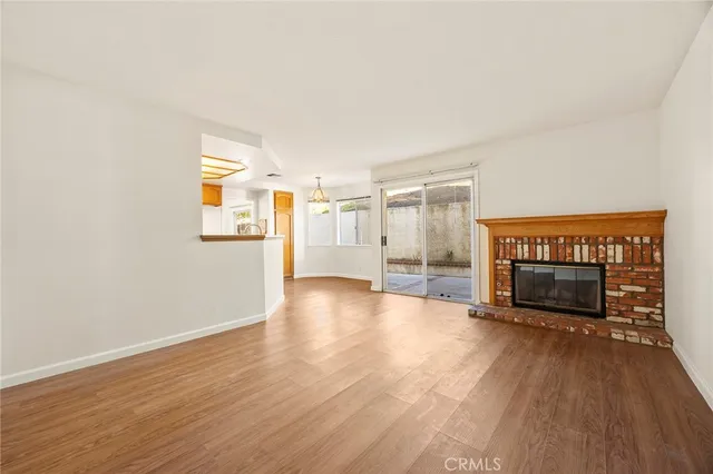 a view of a livingroom with wooden floor and a fireplace