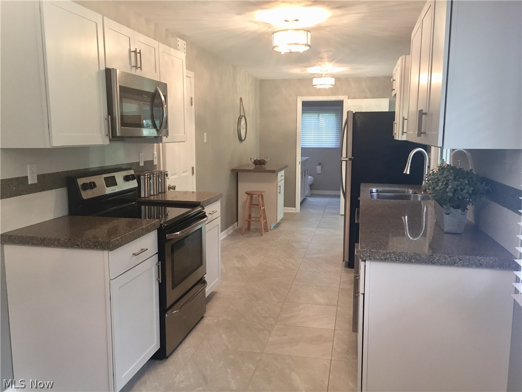 950 East Boston Road Broadview Heights, OH 44147 - Photo 11 of 30 Large kitchen with new cabinets, matching stainless steel appliances, goose neck faucet and granite counter tops. There is a flex space at the end of the kitchen that can be for eating or lounging.