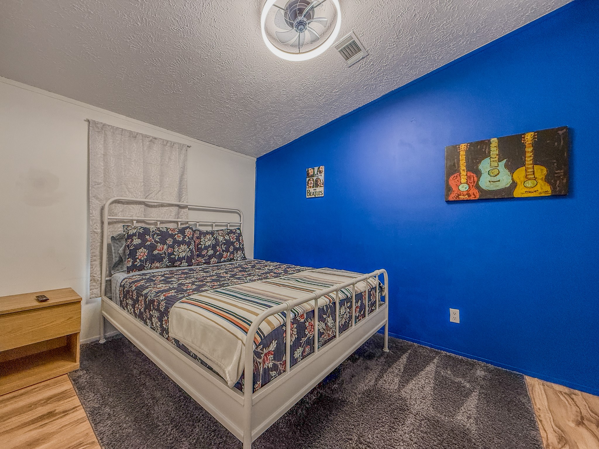 2015 Holly Street Austin, TX 78702 - Photo 15 of 24 A well-lit room featuring partial carpet and wood flooring, with a ceiling fan for comfort.