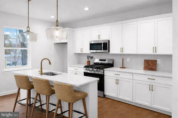 a kitchen with stainless steel appliances granite countertop a sink a stove a microwave a dining table and chairs
