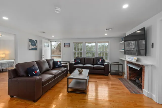 a living room with furniture a fireplace and a flat screen tv