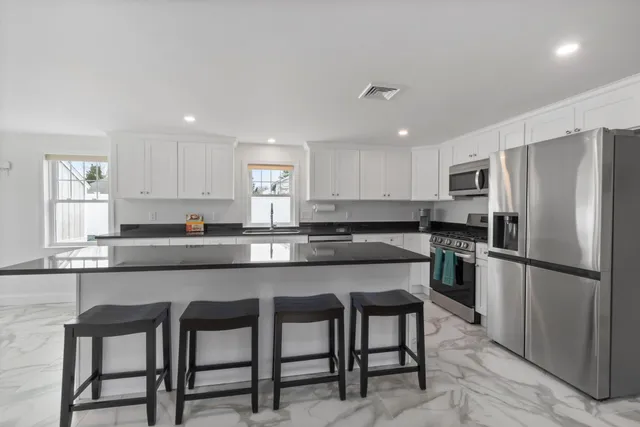 a kitchen with refrigerator and chairs