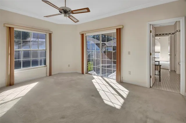 an empty room with windows and cabinet