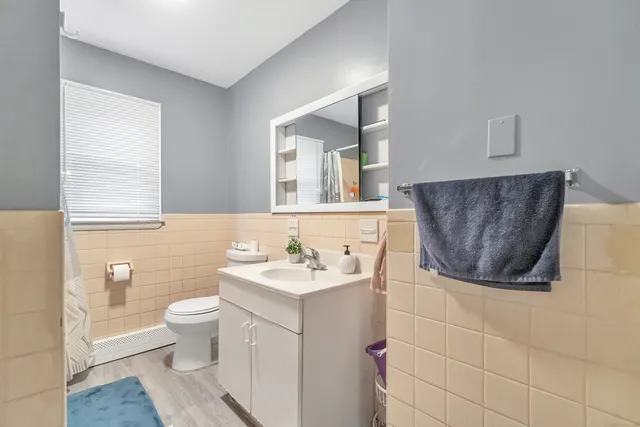 a bathroom with a sink a toilet and mirror