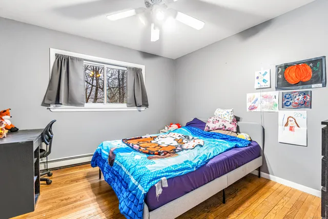 a bedroom with bed and next to a window