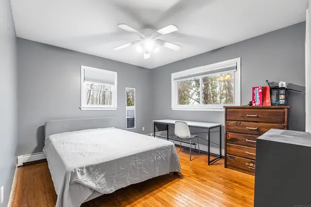 a bedroom with a bed and wooden floor