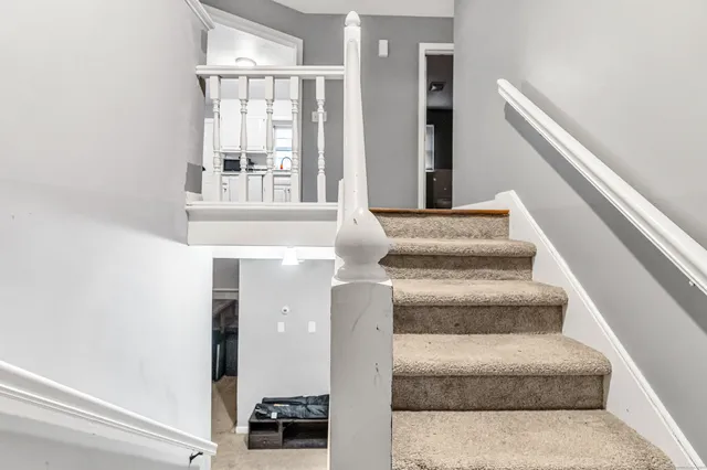 a view of staircase with white walls and a window