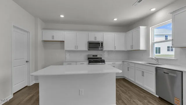 a kitchen with stainless steel appliances a sink stove and cabinets