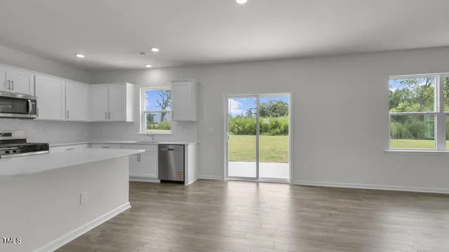 a kitchen with a sink a stove cabinets and wooden floor