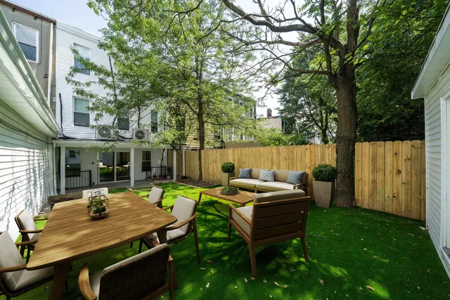 a view of a backyard with table and chairs with wooden fence