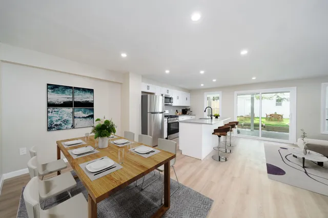 a dining room with furniture and view of kitchen