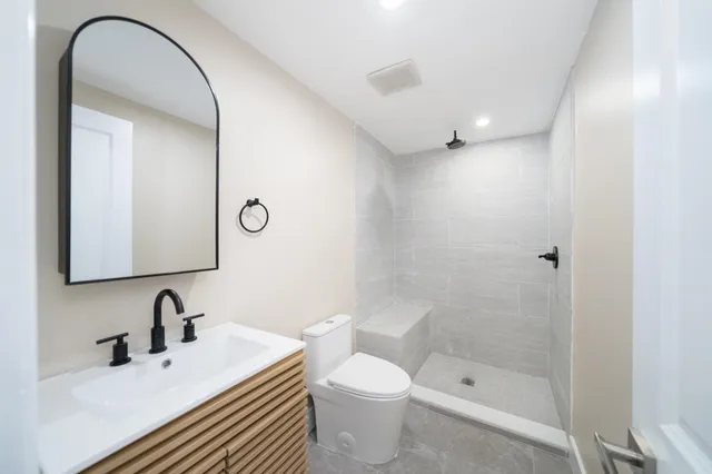 a bathroom with a sink a toilet and shower