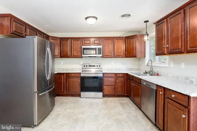 a kitchen with granite countertop stainless steel appliances and wooden cabinets