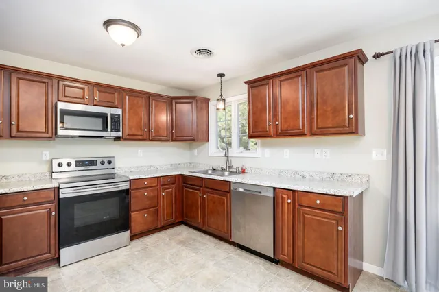 a kitchen with stainless steel appliances granite countertop wooden cabinets a sink and dishwasher