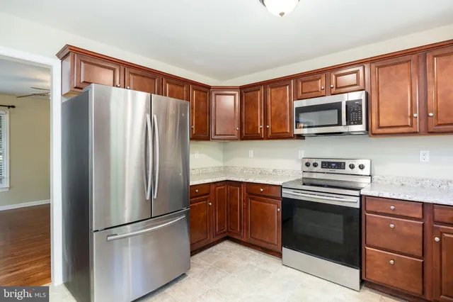 a metallic refrigerator freezer sitting in a kitchen