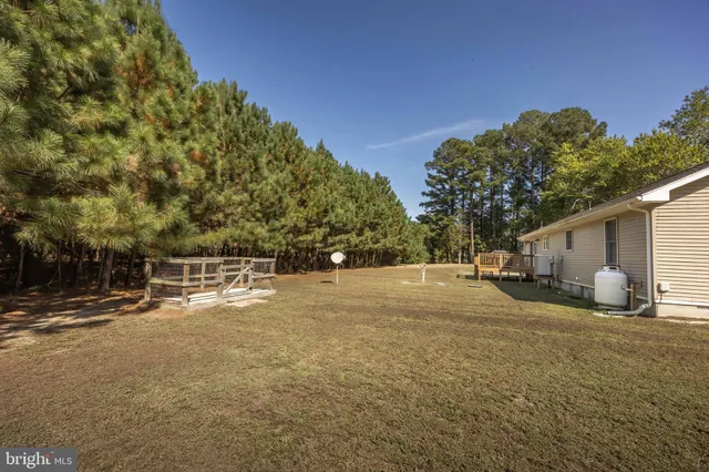 a view of a small house with yard and a trees