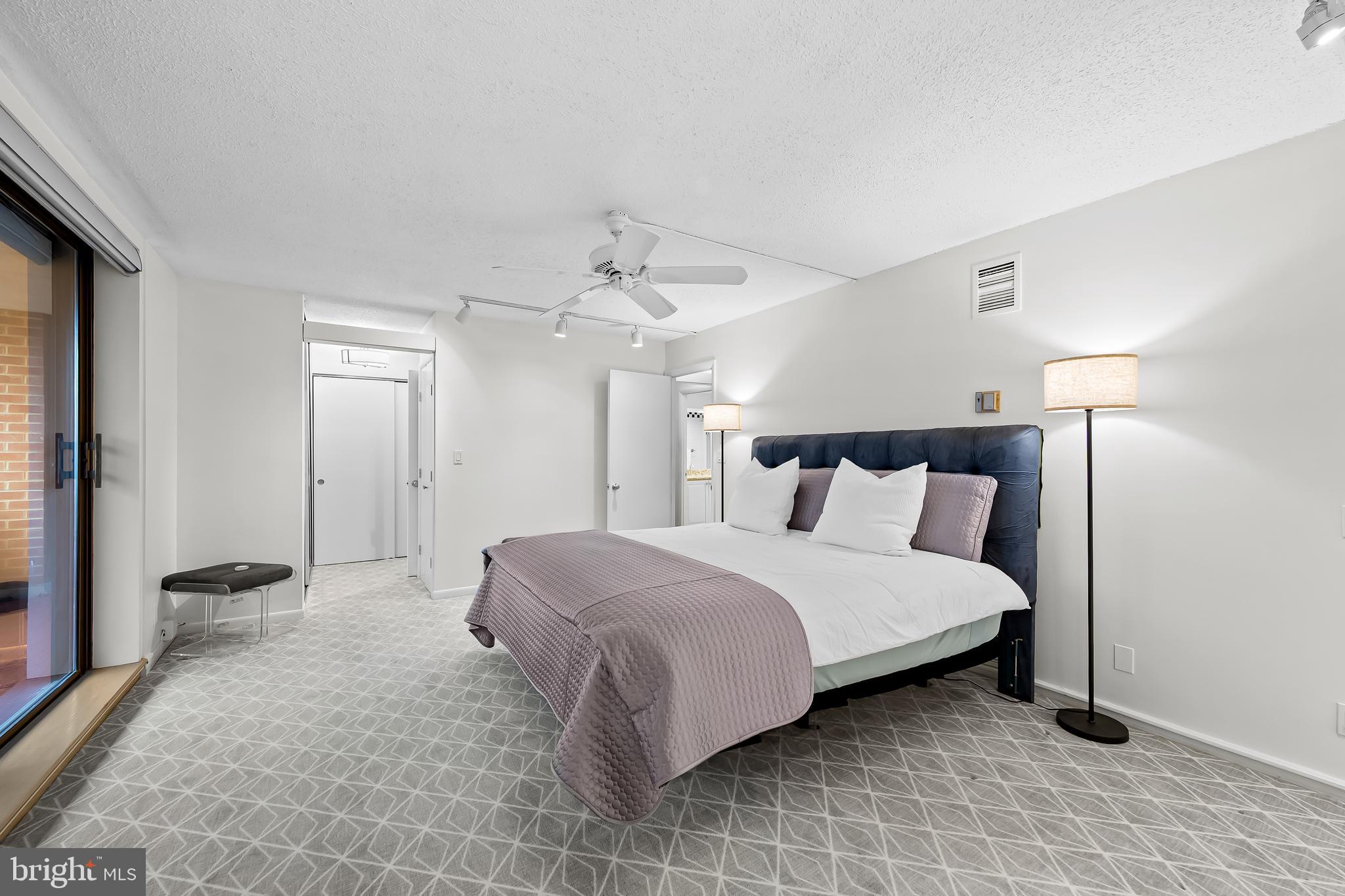 111 Hamlet Hill Road, Unit 1113 Baltimore, MD 21210 - Photo 15 of 27 a spacious bedroom with a bed and a lamp