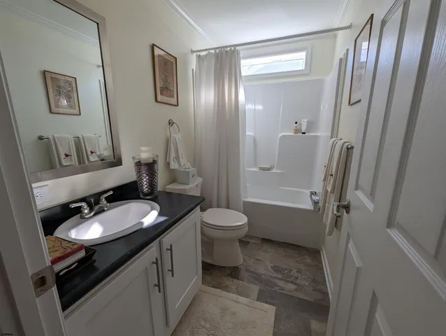 a bathroom with a granite countertop sink toilet a mirror a vanity and shower