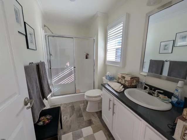a bathroom with a granite countertop sink toilet and shower