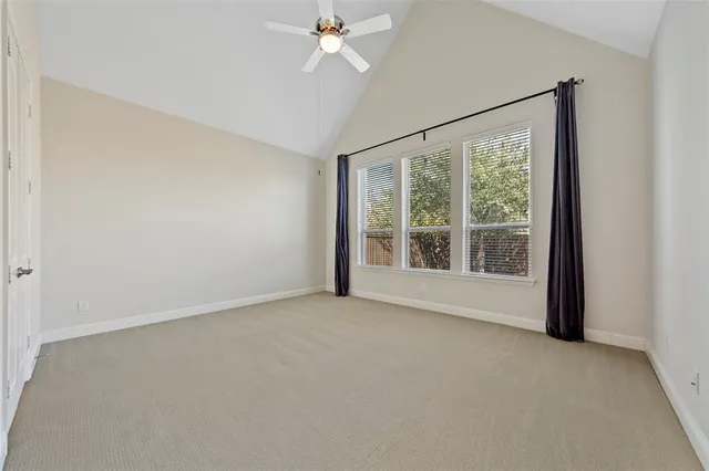 a view of a big room with windows and chandelier fan