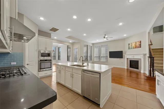 a kitchen with stainless steel appliances granite countertop a sink dishwasher stove top oven and refrigerator