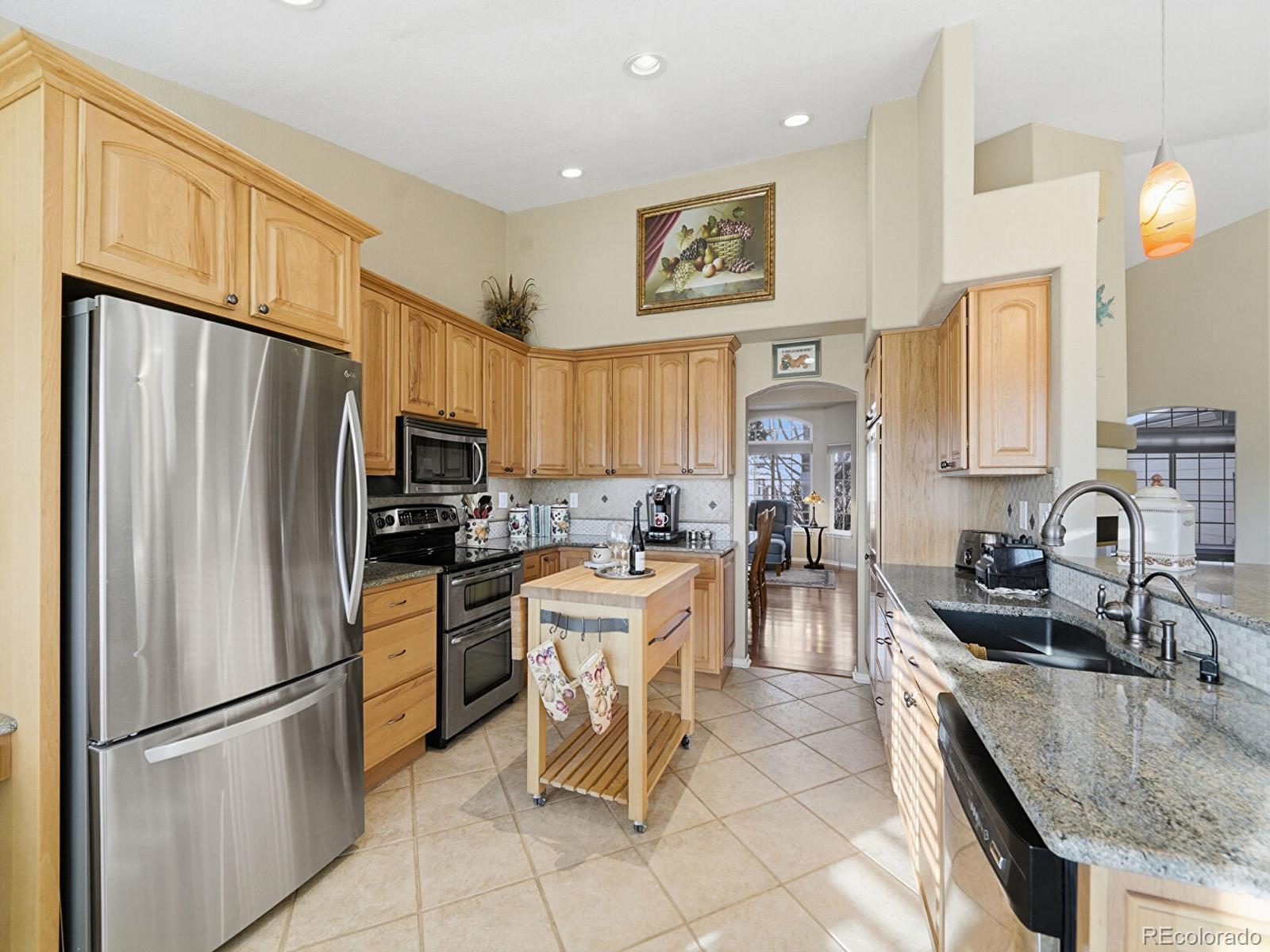 3308 Oak Leaf Place Highlands Ranch, CO 80129 - Photo 14 of 50 a kitchen with stainless steel appliances granite countertop a refrigerator stove microwave and sink