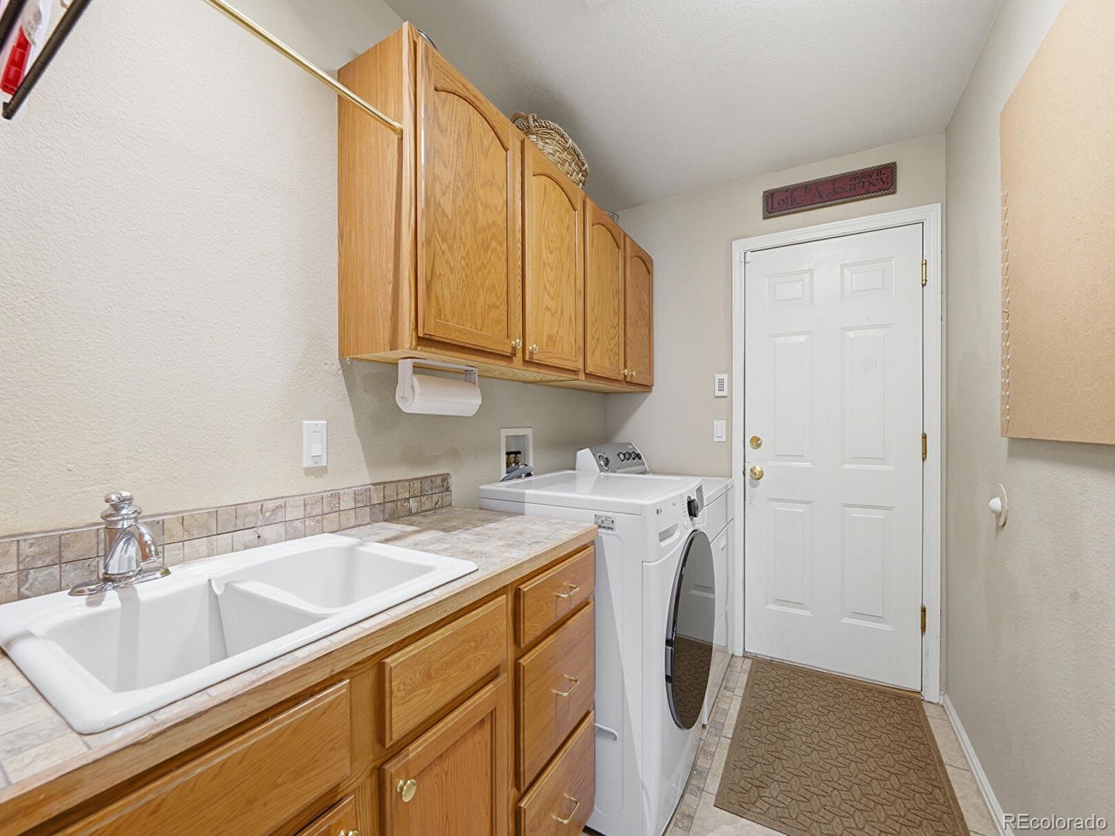 3308 Oak Leaf Place Highlands Ranch, CO 80129 - Photo 23 of 50 a kitchen with a sink cabinets and utility