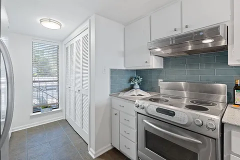 a kitchen with granite countertop white cabinets and white appliances
