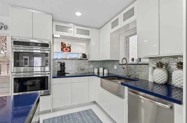 a kitchen with stainless steel appliances granite countertop a sink and stove top oven