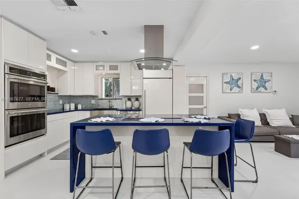 a kitchen with stainless steel appliances granite countertop a stove a sink dishwasher a dining table and chairs