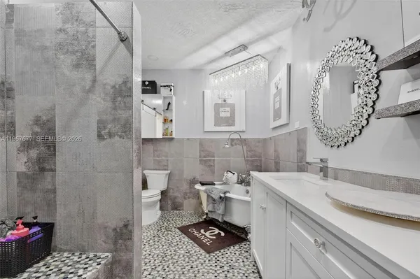 a bathroom with a sink a toilet and shower