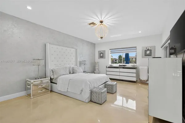 a bedroom with a bed and a chandelier