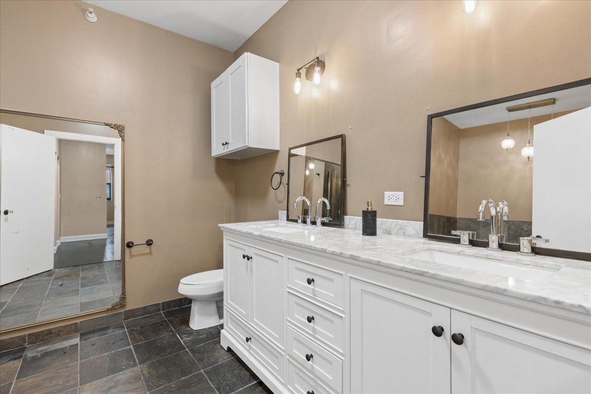 1155 South State Street, Unit 400 Chicago, IL 60605 - Photo 13 of 27 a bathroom with a granite countertop sink a toilet and a mirror