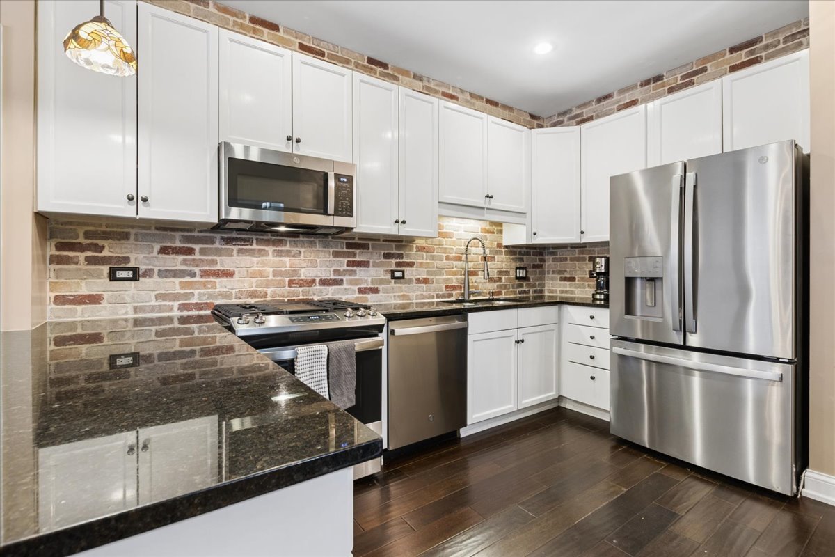 1155 South State Street, Unit 400 Chicago, IL 60605 - Photo 9 of 27 a kitchen with stainless steel appliances white cabinets and a granite counter tops