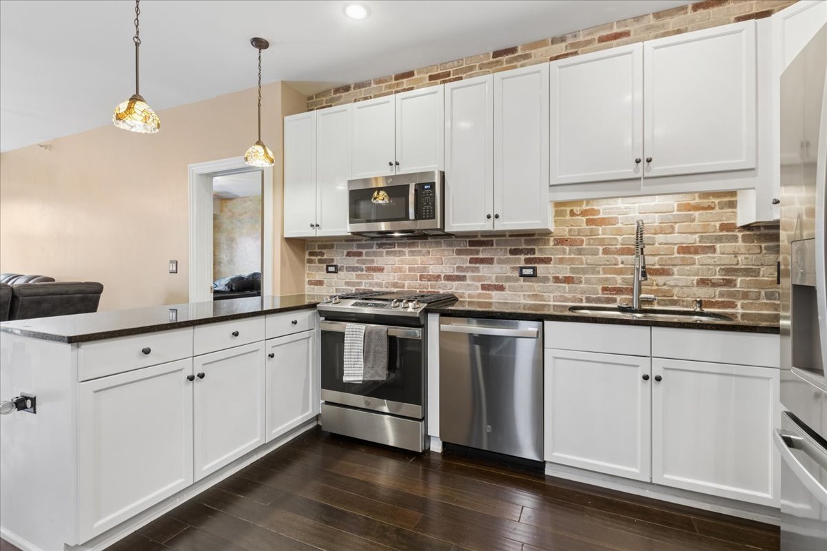 1155 South State Street, Unit 400 Chicago, IL 60605 - Photo 10 of 27 a kitchen with stainless steel appliances granite countertop a stove a sink and white cabinets