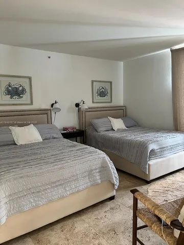 a bedroom with two beds and painting on the wall