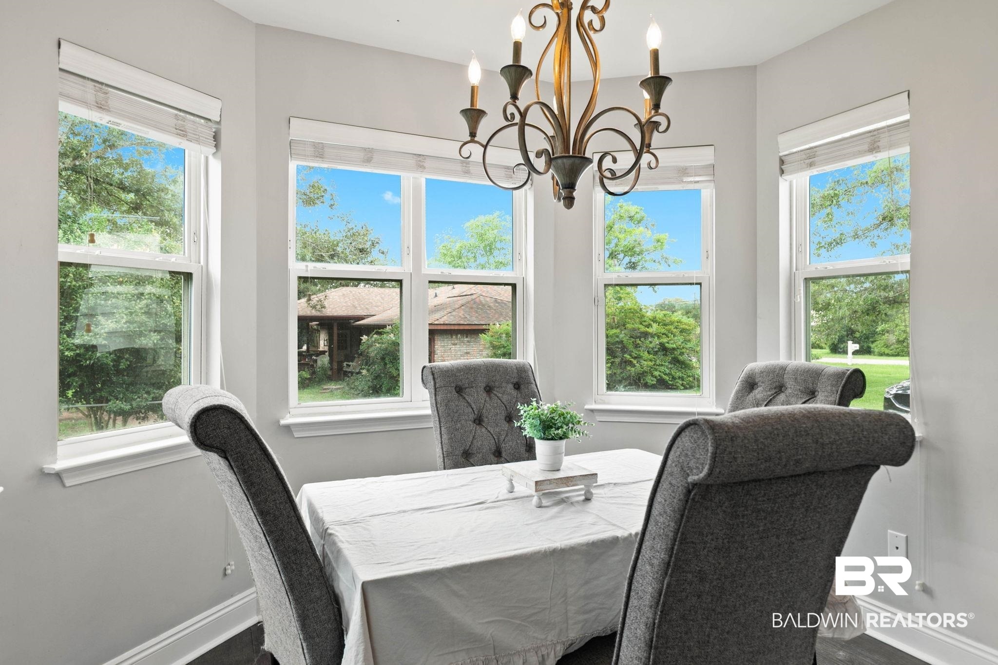 22810 High Ridge Road Fairhope, AL 36532 - Photo 25 of 78 Bay window dining area with a wrought iron chandelier, hardwood flooring, and light gray walls