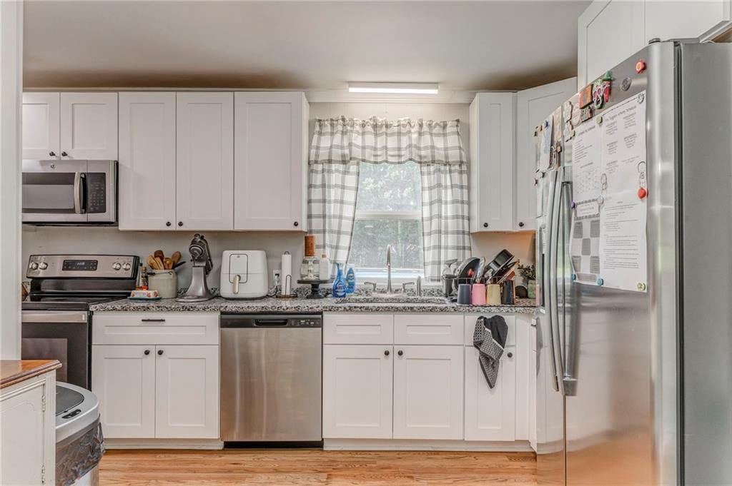 109 Lake Street Rockmart, GA 30153 - Photo 16 of 50 a kitchen with stainless steel appliances granite countertop a refrigerator sink and white cabinets