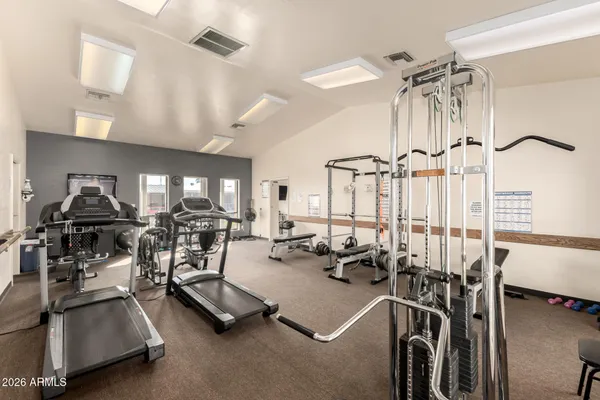 a living room with furniture gym equipment and a large window