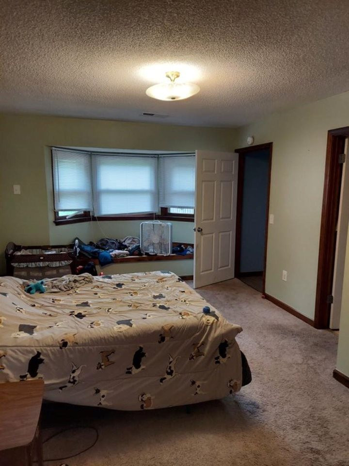 3766 South Bluff Road Obion, TN 38240 - Photo 6 of 8 a spacious bedroom with a bed and a large mirror