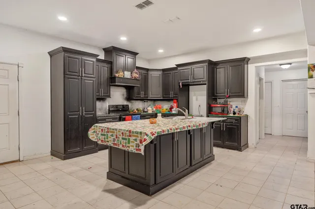a kitchen with stainless steel appliances granite countertop a refrigerator and a stove