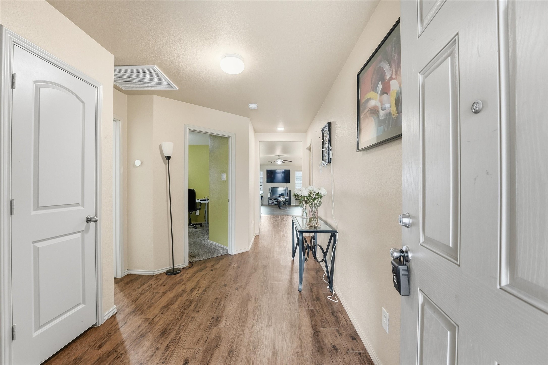 15455 Rancho Joya Way Houston, TX 77049 - Photo 3 of 20 a hallway with white cabinets and wooden floor